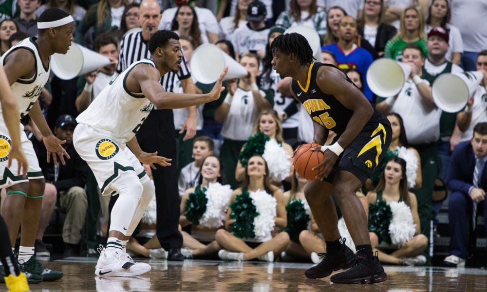 Junior forward Xavier Tillman blocks the ball from Iowa forward Tyler Cook (25) during the game against Iowa University at Breslin Center on Dec. 3, 2018. The Spartans defeated the Hawkeyes, 90-68.