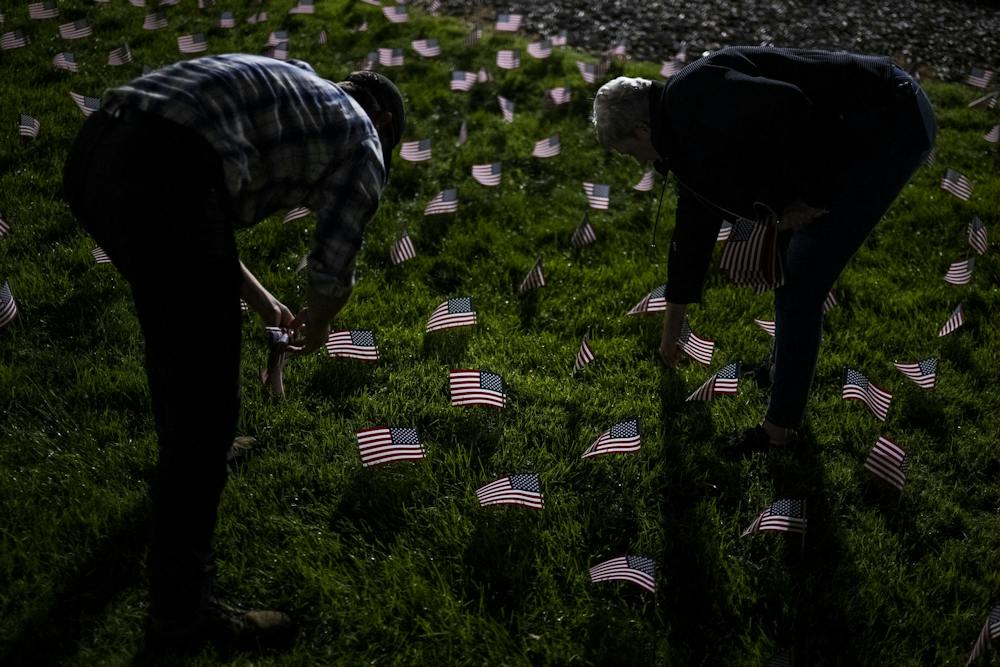 Damean Knapp, a veteran and sophomore studying information technology at Central Michigan University, and Marry Shinkle, Ingham County GOP chair, place American flags around the Rock during preparations for a 9/11 memorial at Michigan State University in East Lansing, Mich., Thursday, Sept. 10, 2026. MSU Young Americans for Freedom and MSU College Republicans placed 2,977 flags, one for each victim killed in the Sept. 11, 2001, terrorist attacks, to mark the 25th anniversary of the attacks.