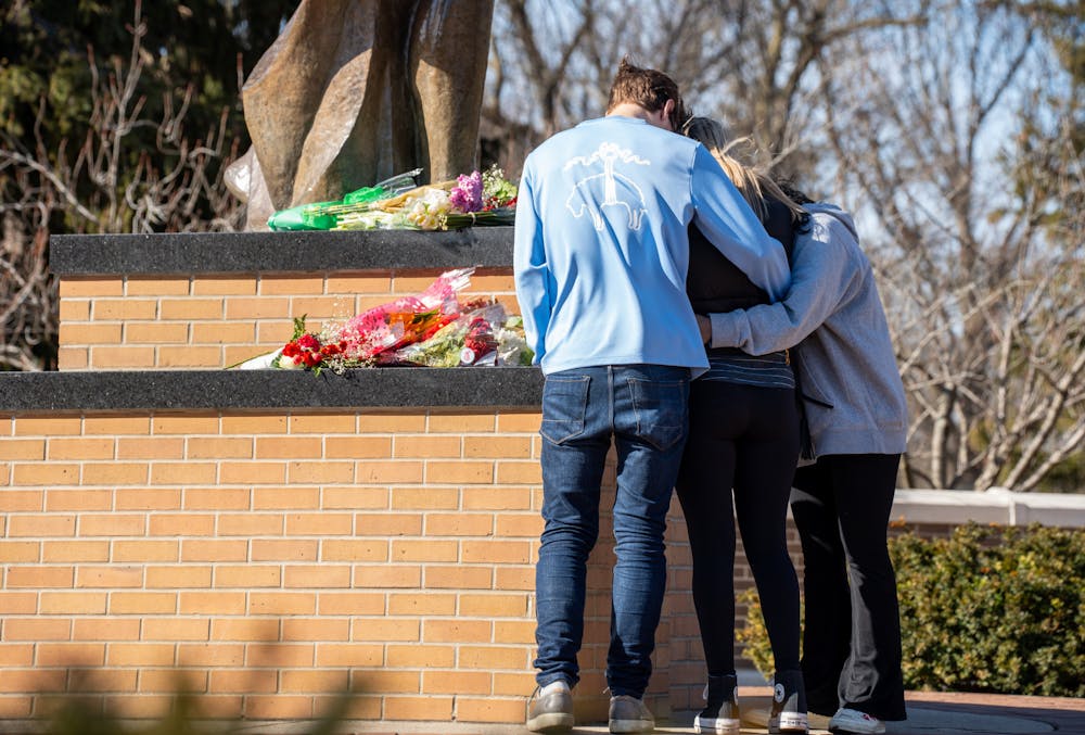 Students stand at the foot of the Spartan statue on Feb. 14, 2023, one day after a mass shooting took place in Michigan State University's North Neighborhood.