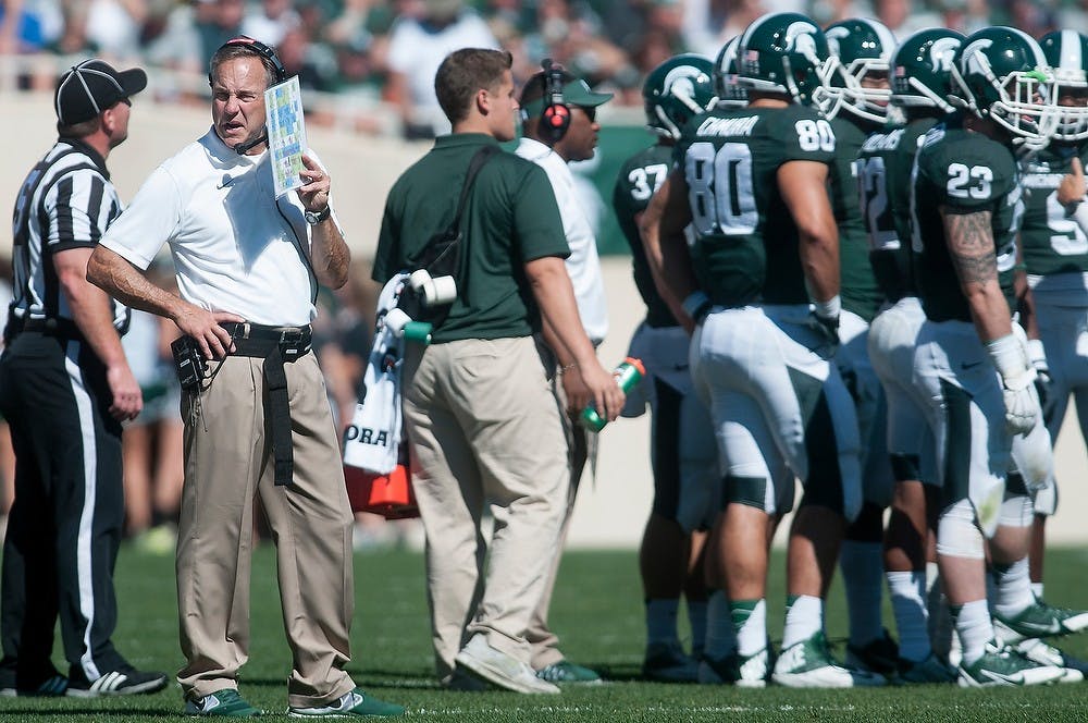 <p>Head coach Mark Dantonio talks into his headset during a timeout during the game against Wyoming on Sept. 27, 2014, at Spartan Stadium. The Spartans defeated the Cowboys, 56-14. Julia Nagy/The State News</p>
