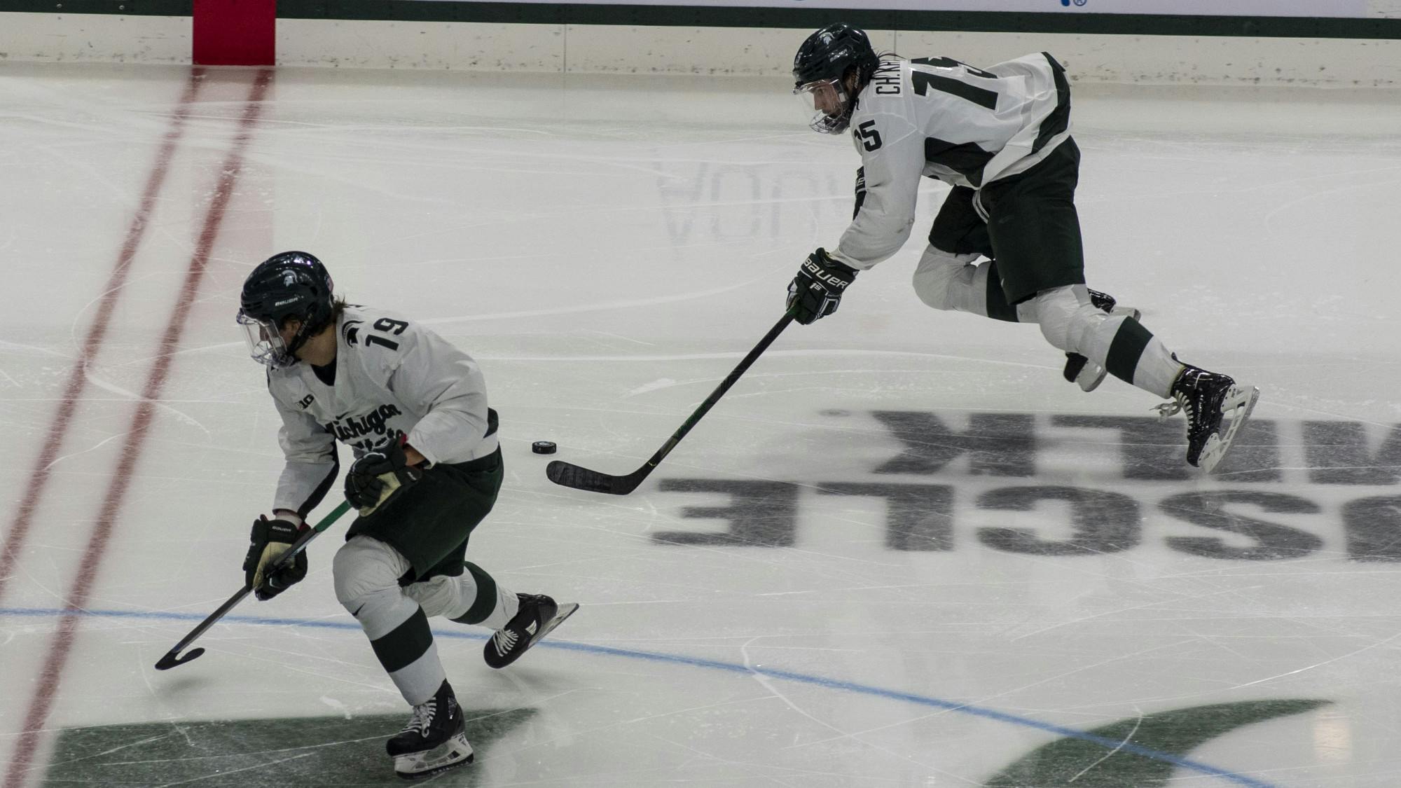 Junior left defenseman Christian Krygier (15) and sophomore right wing Nicolas Müller (19) pass the puck back and forth to each other during the third period. The Spartans triumphed against the Sun Devils, 2-0, on November 20, 2020.