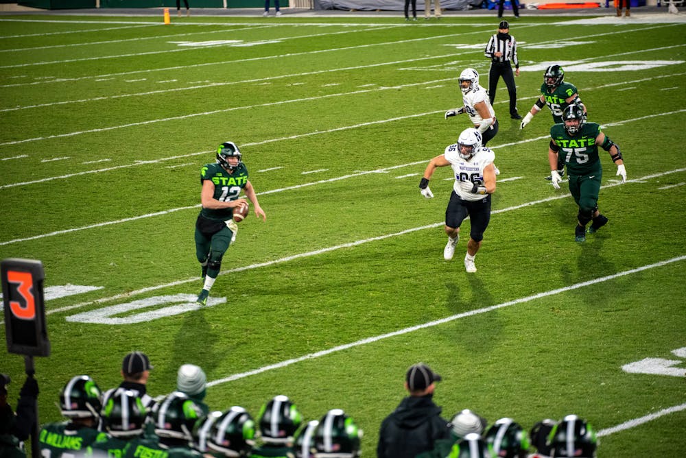 <p>Michigan State University quarterback Rocky Lombardi breaking out of the pocket to run for first down against Northwestern on Saturday, Nov. 28, 2020.</p>
