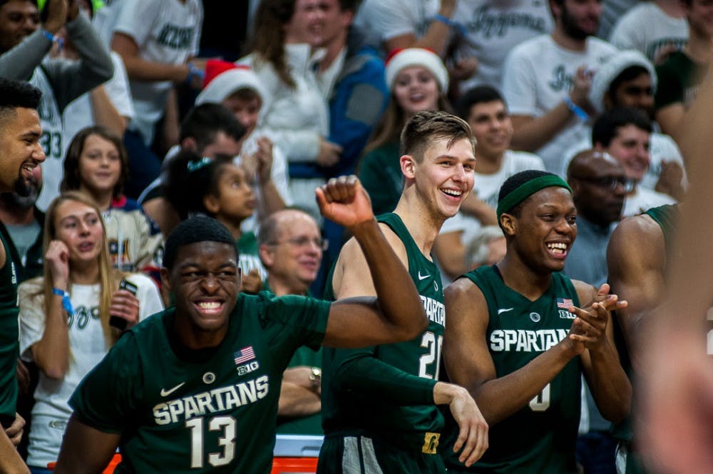 Freshman forward Gabe Brown (13), senior guard Matt McQuaid (21) and junior guard Cassius Winston (5) cheer during the game against Tenessee Tech on Nov. 18, 2018 at the Breslin Center. The Spartans beat the Golden Eagles, 101-33.