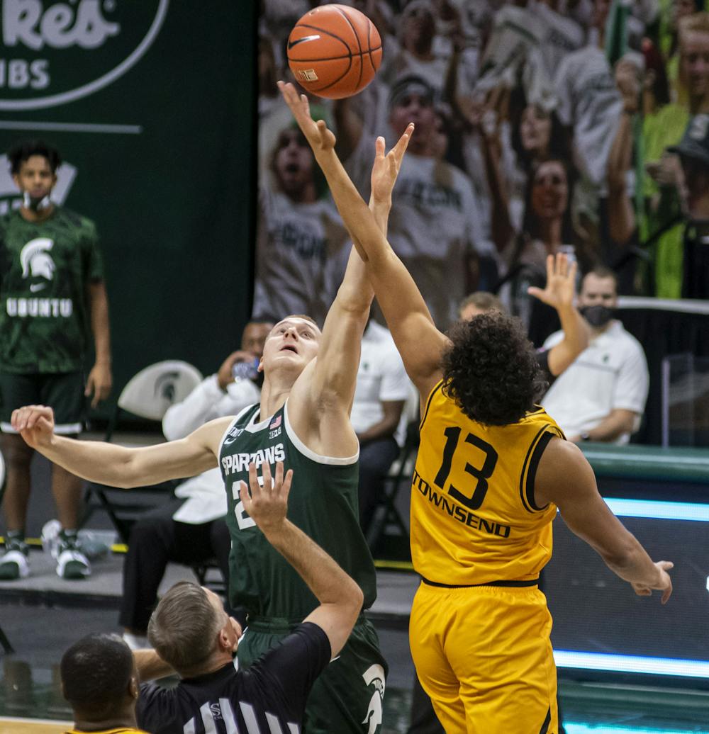 <p>Redshirt junior forward Joey Hauser (20) tips the ball off to start the Michigan State game against Oakland. The Spartans came back after the first half to pull out a 109-91 win on Dec. 13, 2020.</p>