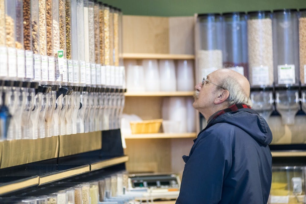 East Lansing resident Eugene Kales looks at a variety of grains on Jan. 7, 2017 at the East Lansing Food Cooperative at 4960 Northwind Drive in East Lansing. Kales said he has visited the East Lansing Food Cooperative since it opened and shops about once a week. The East Lansing Food Cooperative is closing on Feb. 4, 2017.