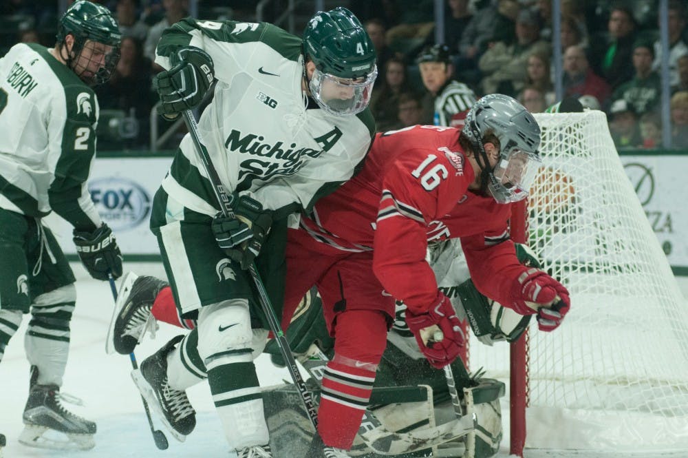 Senior defense Matthew Weis  tries to steal the puck from forward Matthew Weis during a  hockey game against Ohio Stat on March 12, 2016 at Munn Ice Arena. The Spartans tied 1-1 and won to Buckeyes in a shoot out./ 1-0