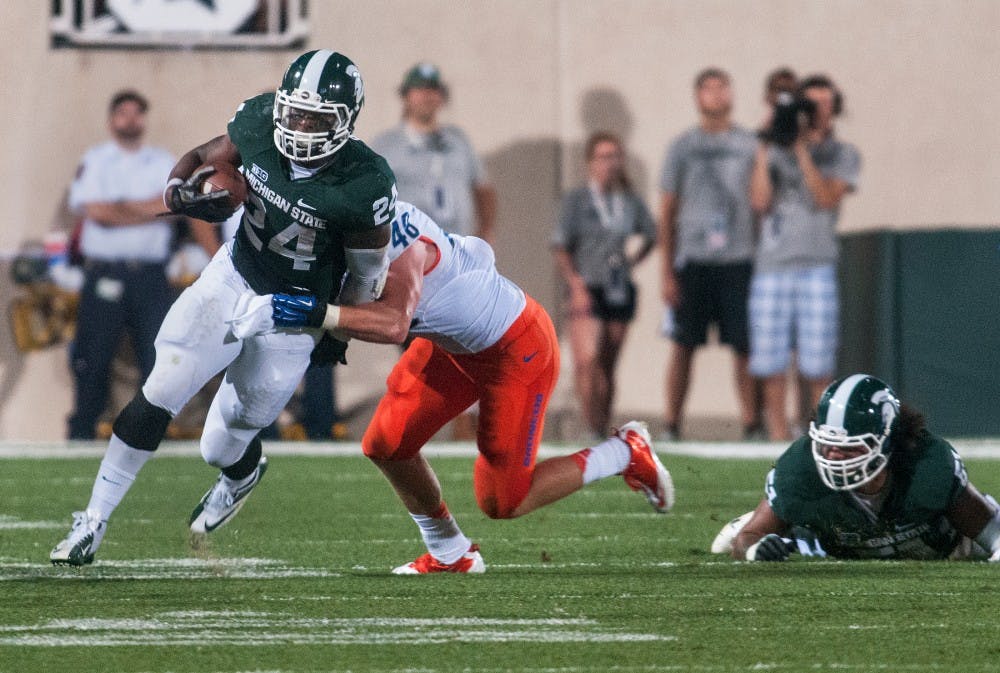 Junior running back Le'Veon Bell brakes a tackle Friday night Aug. 31, 2012 at Spartan Stadium. Bell ran for a career high 210 yards in a 17-13 win against Boise State in the Spartans home opener. Adam Toolin/The State News