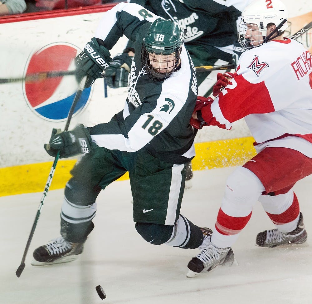 	<p>Senior forward Kevin Walrod tries to retrieve the puck before Miami (Ohio) defenseman Taylor Richart during the game Friday, March 15, 2013, at Cady Arena of the Goggin Ice Center in Oxford, Ohio. <span class="caps">MSU</span> beat Miami (Ohio) 3-0 in the first game of the second round of the <span class="caps">CCHA</span> playoffs. Danyelle Morrow/The State News</p>