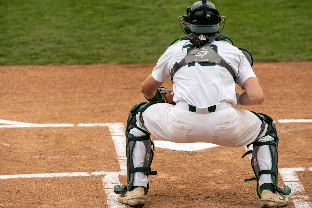 <p>Redshirt freshman catcher Bryan Broeker warms up with the pitcher before the Wednesday game against Western Michigan. The Spartans lost 18-7 on April 13, 2022. </p>