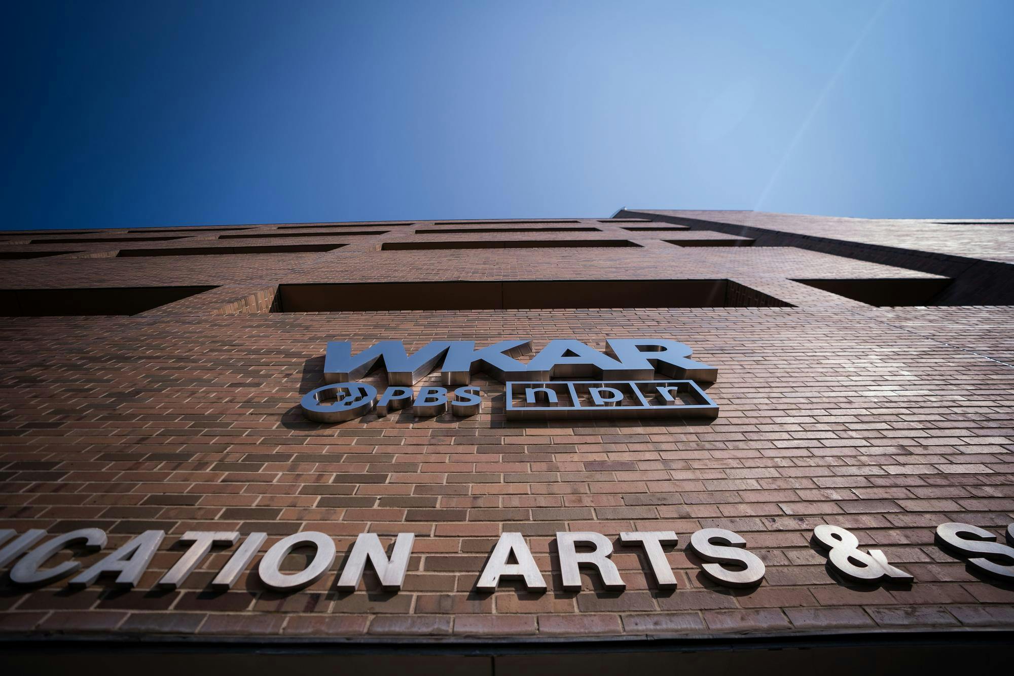 The sun shines on the Michigan State University Communication Arts and Sciences Building on Sept. 11, 2024. The WKAR, PBS and NPR logos were added to the building in May 2024.