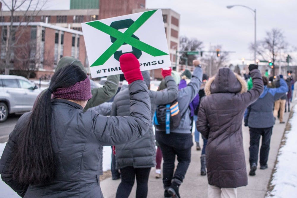 The crowd at the March for Transparency walks from the Rock on Farm Lane to the Hannah Administration Building in silence with their fists raised in solidarity with sexual assault survivors on Feb. 2, 2018.