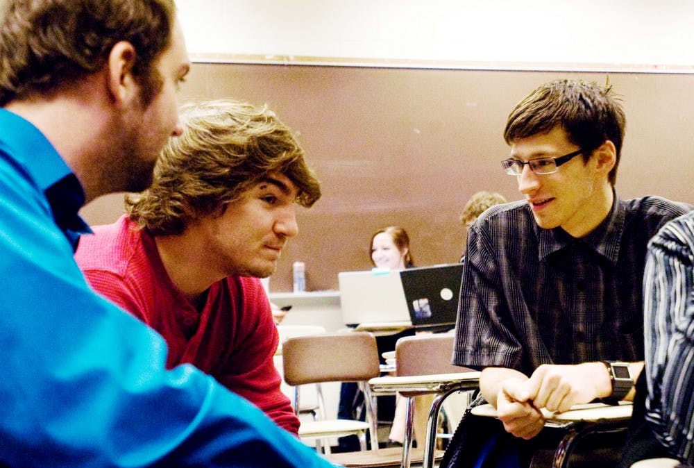 From right computer science juniors Benjamin Szymczak and Alex Lockwood converse with media arts and technology junior Scott Compau before they  presented their video game idea to the TC 455, Game Design and Development II, class Tuesday afternoon. Samantha Radecki/The State News