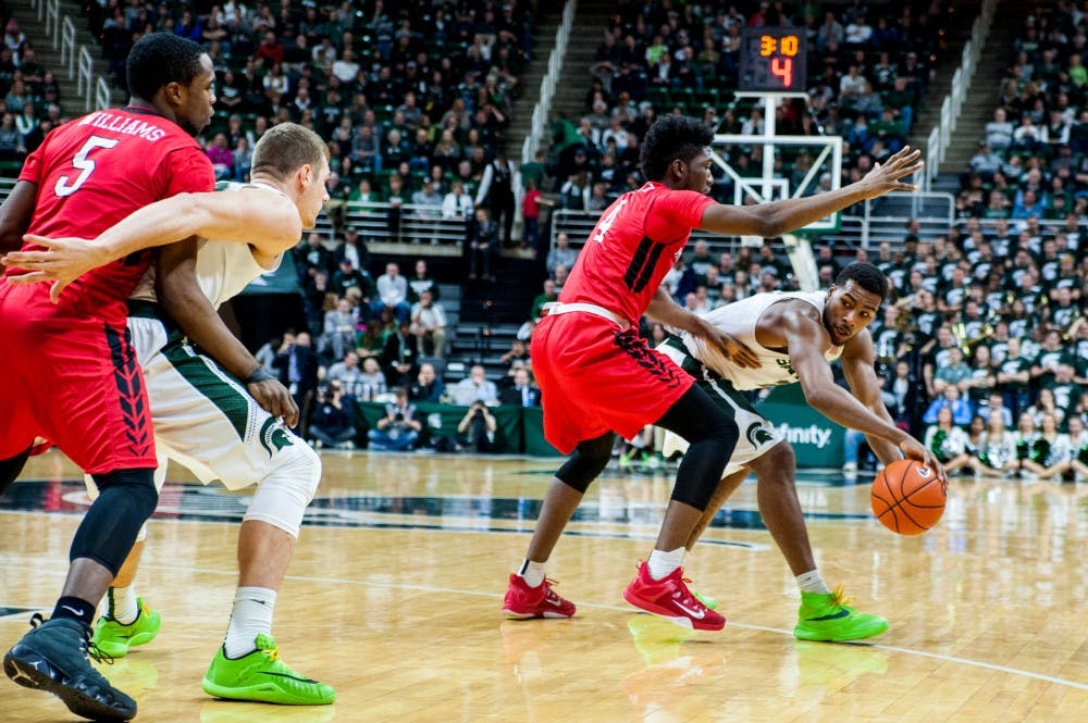 Sophomore forward Javon Bess looks to pass the ball around Rutgers forward Jonathon Laurent during the second half of the game against Rutgers on Jan. 31, 2016 at Breslin Center. The Spartans defeated the Scarlet Knights, 96-62. 