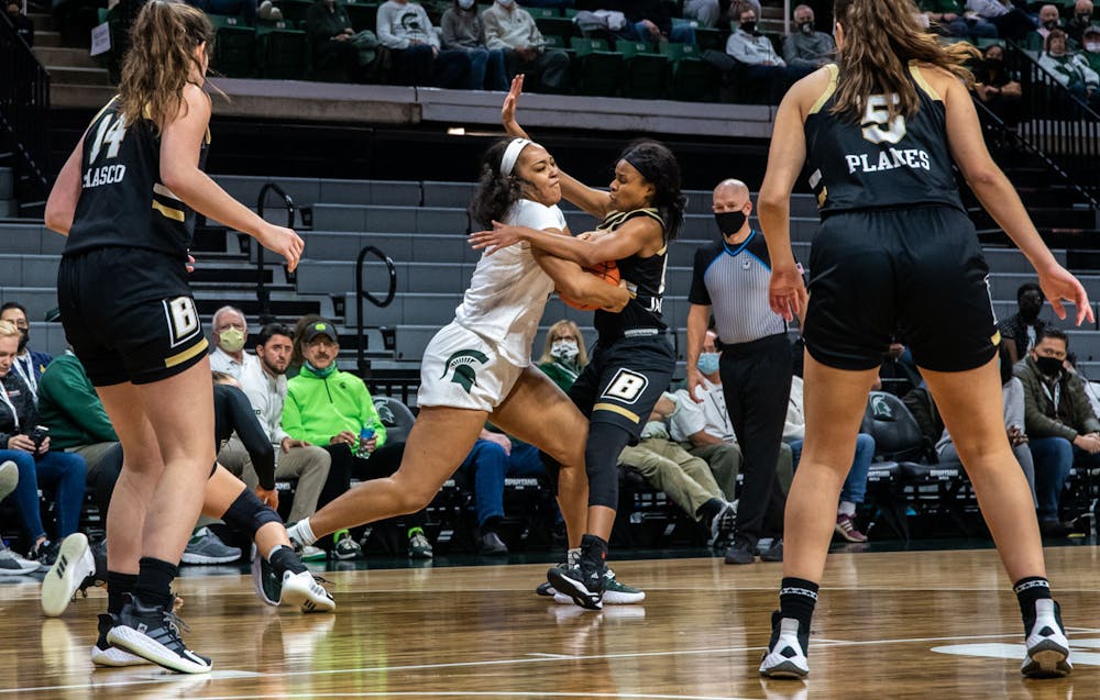 Junior forward Taiyier Parks (14) shoves a Bryant player down and gets a personal foul in the third quarter. The Spartans crushed the Bulldogs, 100-60, which led coach Suzy Merchant to her 300th win with Michigan State on Nov. 19, 2021.