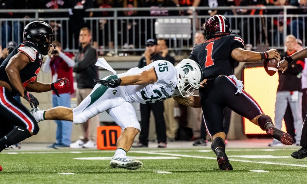 <p>Senior linebacker Joe Bachie (35) sacks Ohio State quarterback Justin Fields (1). The Buckeyes defeated the Spartans, 34-10, on Oct. 5, 2019 at Ohio Stadium. </p>