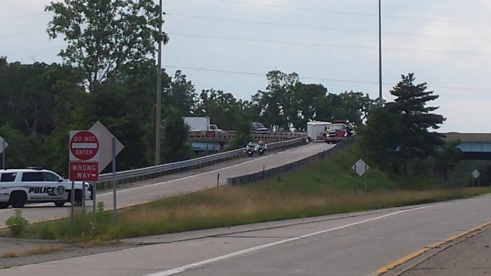 <p>Workers make efforts to reopen the northbound US 127 exit to Trowbridge Road on June 29, 2015, after an accident involving a semi-truck closed the off-ramp.</p>