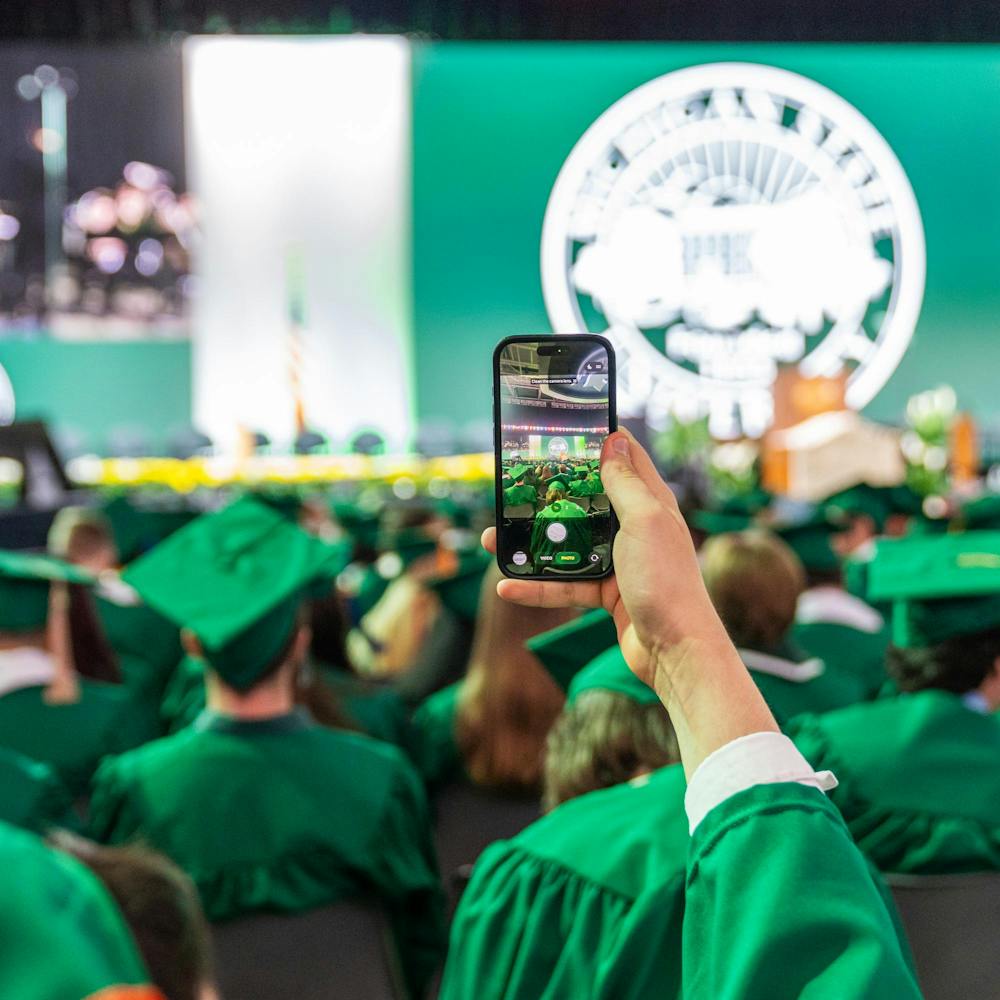 <p>A Michigan State future graduate holds their phone up to take a picture in East Lansing, Mich., on May 1, 2026.</p>