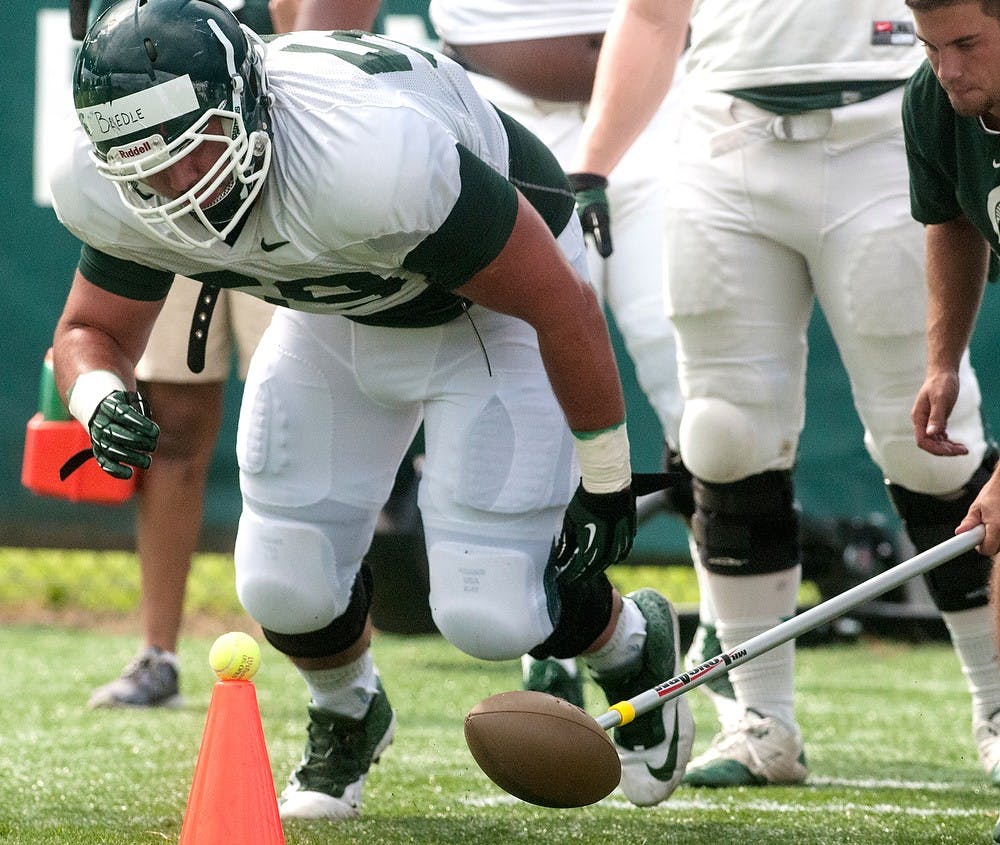 <p>Freshman defensive tackle David Beedle participates in practice drills, Aug. 6, 2014, at the practice field outside Duffy Daugherty Football Building. The football season kicks off on Aug. 29 with a game against Jacksonville State. Jessalyn Tamez/The State News</p>