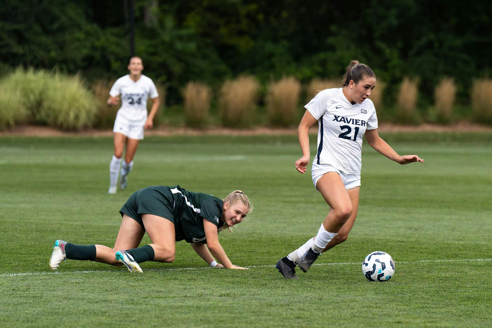 <p>Michigan State freshman midfielder Grace Jackson (8) looks at the ball from the ground as Xavier University freshman defender McKinley Berry (21) takes the ball at DeMartin Soccer Stadium on Sept. 1, 2024.</p>