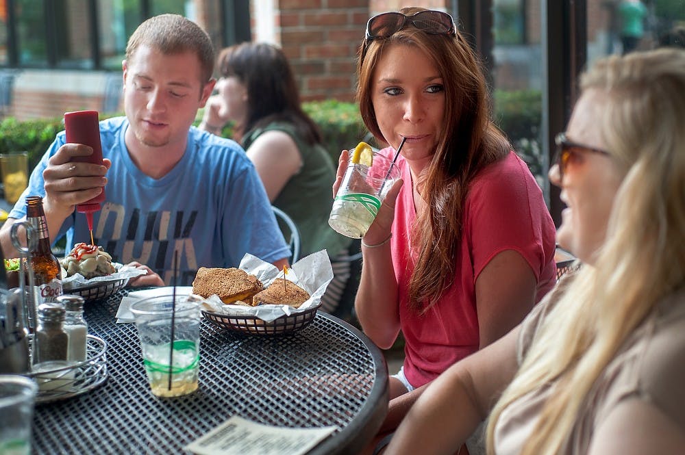 <p>From left, Lansing resident and LCC student Andrew Weinberg, recent graduates and East Lansing residents Katie Blaszkowski and Katherine Miller dine at the patio, June 11, 2013, at Peanut Barrel, 521 E. Grand River Ave. Justin Wan/The State News</p>