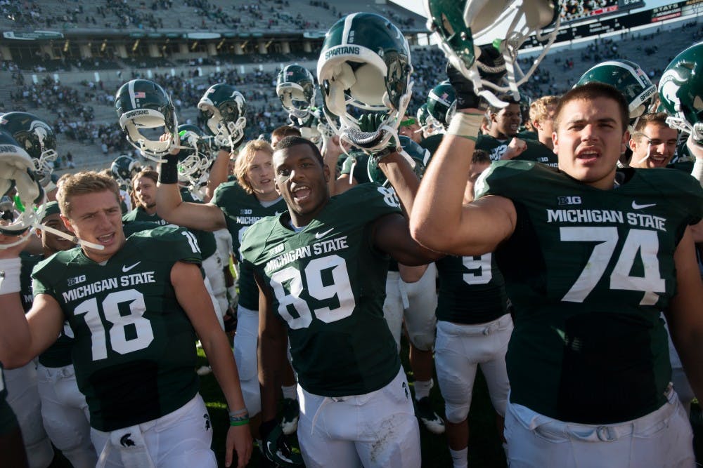 <p>Then-sophomore quarterback Connor Cook, 18, then-defensive end Shilique Calhoun, 89, and then-freshman offensive tackle Jack Conklin sing the fight song after defeated Youngstown State on Sept. 14, 2013, at Spartan Stadium.</p>