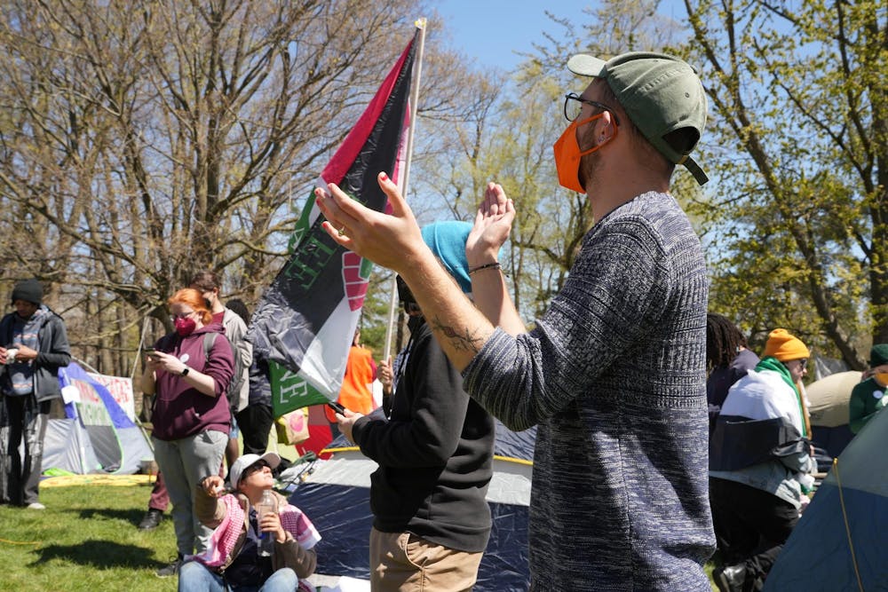 A student claps along with fellow protesters during a Gaza solidarity encampment in People’s Park on April 25, 2024.