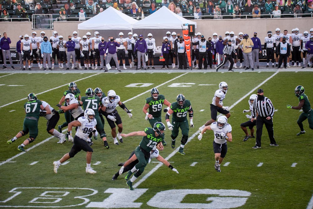 <p>Michigan State quarterback Rocky Lombardi (12) leaving the pocket to run the ball in the game against Northwestern on Saturday, Nov. 28, 2020.</p>