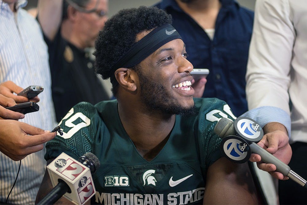 <p>Starting defensive end Shilique Calhoun attracts a big crowd of media around his table during media day August 10, 2015 at Spartan Stadium. Catherine Ferland/ The State News</p>