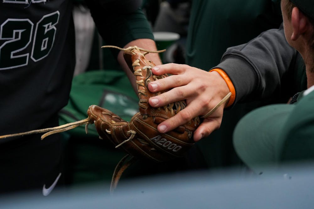 Michigan State redshirt senior Dominic Pianto (26) receives a high five after pitching on April 26, 2025. The Spartans lost to the Wolverines in the second game 9-2.