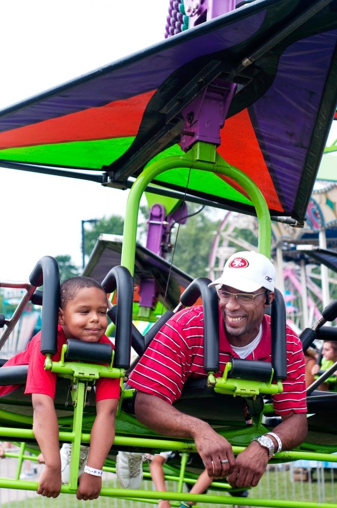 	<p>Lansing residents Keith Scott and Keith Scott Jr., 6, enjoy a ride Tuesday afternoon at the ingham County Fair.</p>