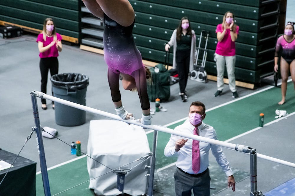 <p>Head Coach Mike Rowe watches an MSU Gymnast on the bars at MSU&#x27;s tri-meet against Ohio State and Nebraska on Jan. 30 at the Jenison Fieldhouse. The Spartans took a win with 195.775 points.</p>