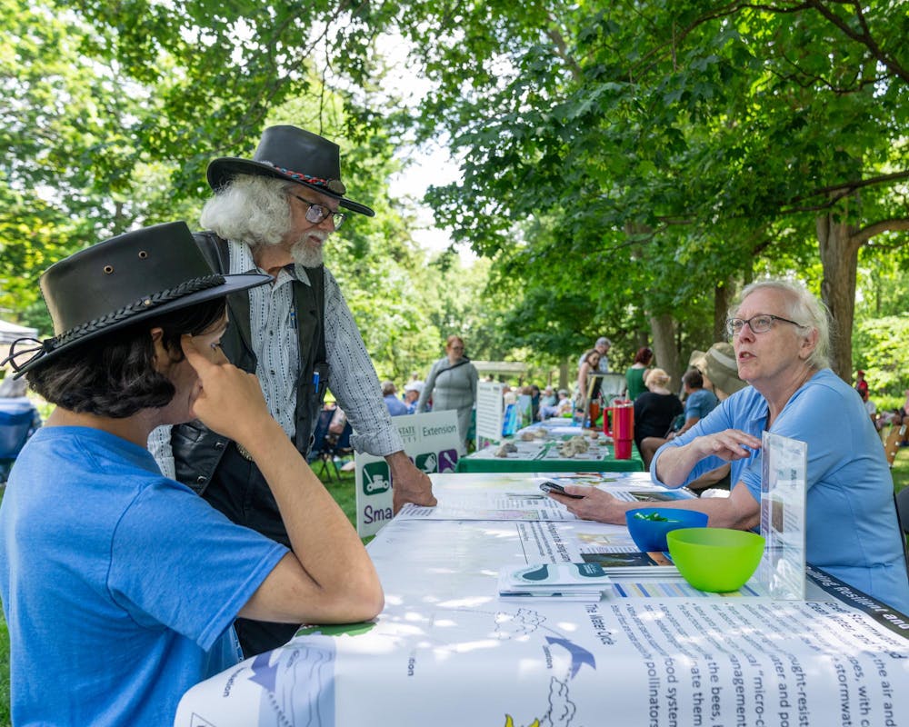 <p>Music and the Garden attendees talk with a MidMichigan Environmental Action Council volunteer in the W.J. Beal Botanical Garden in East Lansing, Mich., on June 28, 2026.</p>