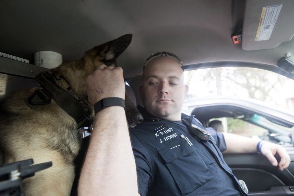 K-9 Patrol Officer Justin Horst pets his German Shepherd, Aries, who stays with him permanently on March 17, 2016 in East Lansing.  Aries stays with Horst in the back of police car and goes with him everywhere. 