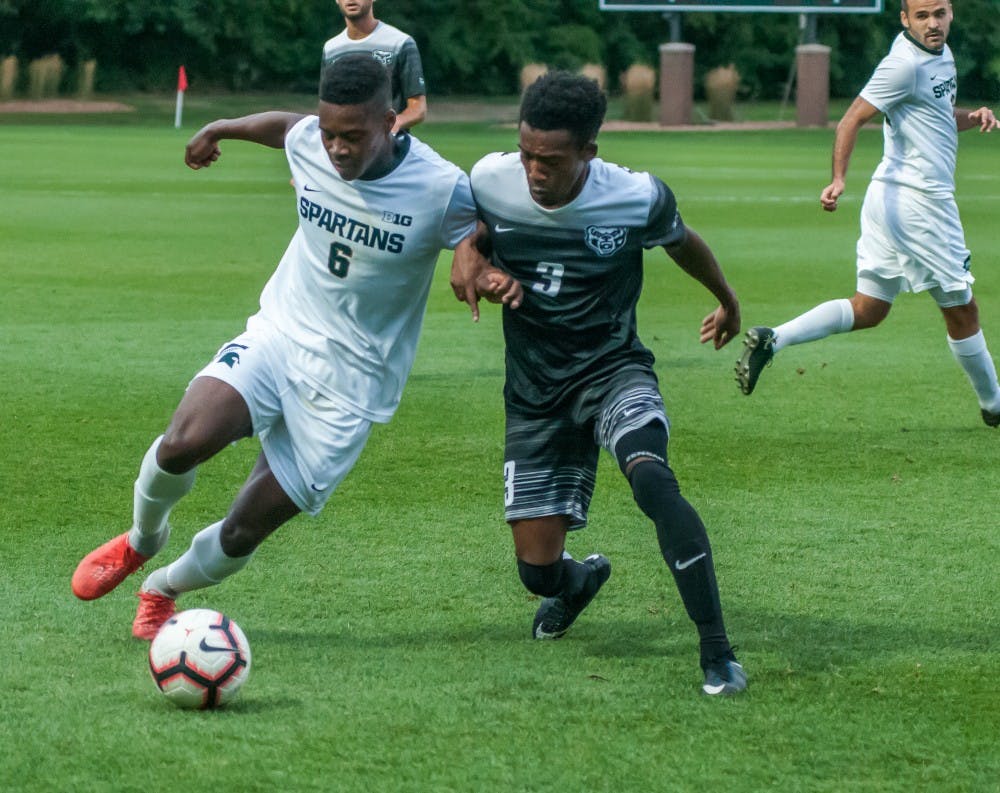 Senior forward Dejuan Jones (6) leans on the defender while bringing the ball up the field during the game against Oakland on Sept. 10, 2018 at DeMartin Stadium. The Spartans defeated the Golden Grizzlies; 4-2.