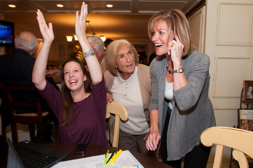 54B District Judge candidate Andrea Larkin, far right, reacts in shock to winning precinct ten as her campaign manager Samantha Artley, far left, claps on Tuesday, Nov. 6, 2012, in Larkin's home in East Lansing. Larkin's mother Grace Andrews, center, congratulated her daughter. Julia Nagy/The State News