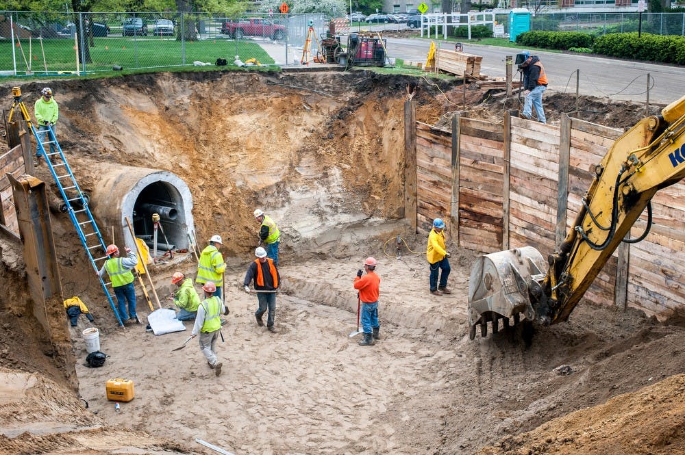 	<p>Workers gather around a tunnel near Main Library on May 10, 2013, at the West Circle Steam Loop Segment 2. Justin Wan/The State News</p>