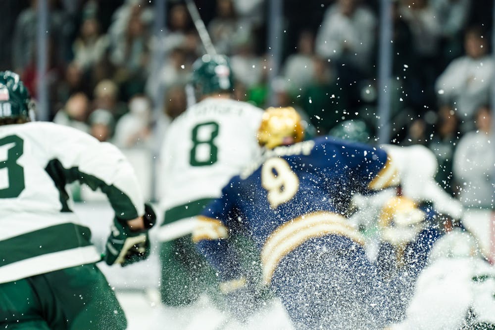 <p>5th-year defense Cole Kyrgier (8) tosses up a cloud of ice while beating Notre Dame's #9 to the puck (3-2) on Feb. 4, 2023.</p>