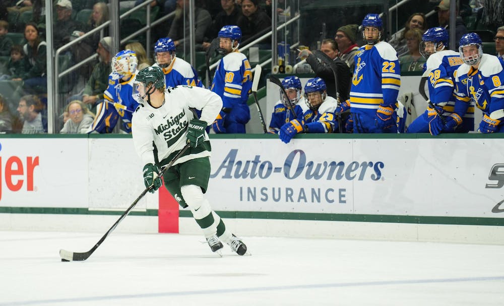 MSU defenseman Maxim Štrbák carries the puck past the opposing bench at Munn Ice Arena on Saturday, Oct. 7, 2023. The Spartans won the early evening matchup against Lake Superior State 5-2.