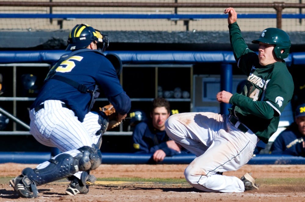 Senior center fielder Brian Eckerle slides as Michigan catcher Zach Johnson attempts to guard the plate Sunday at Ray Fisher Stadium at Wilpon Baseball Complex in Ann Arbor. The Spartans defeated the Wolverines, 8-2 to take both games of a double header. Matt Radick/The State News