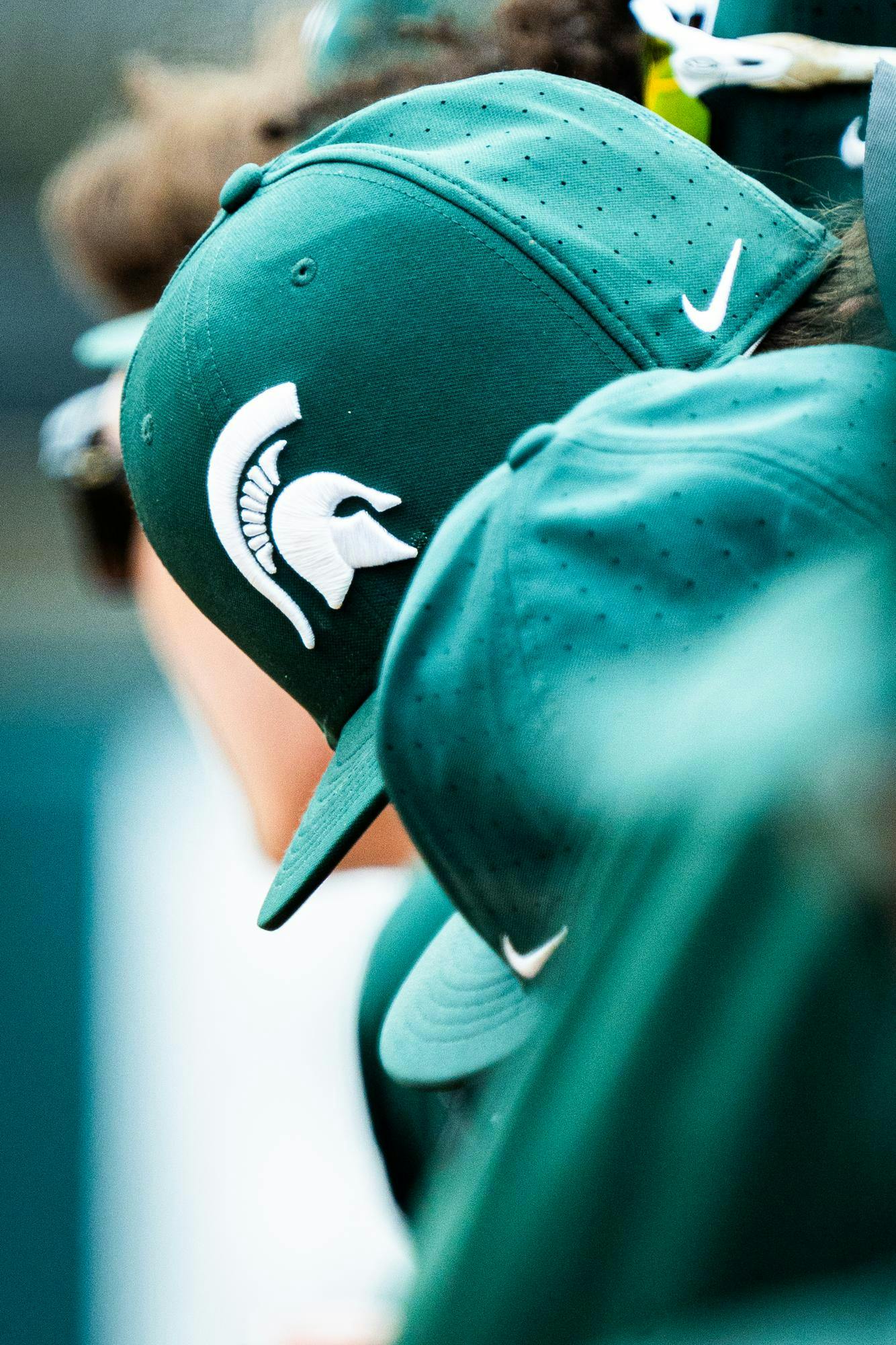 An MSU baseball player converses with a teammate during a game at McLane Stadium on April 13, 2025.