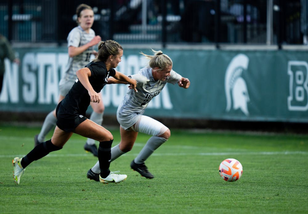 <p>Graduate student midfielder Abby Gardiner (22) fights off an Iowa player at DeMartin Stadium on Sept. 22, 2022. Spartans tied with the Hawkeyes with a score of 0-0. </p>