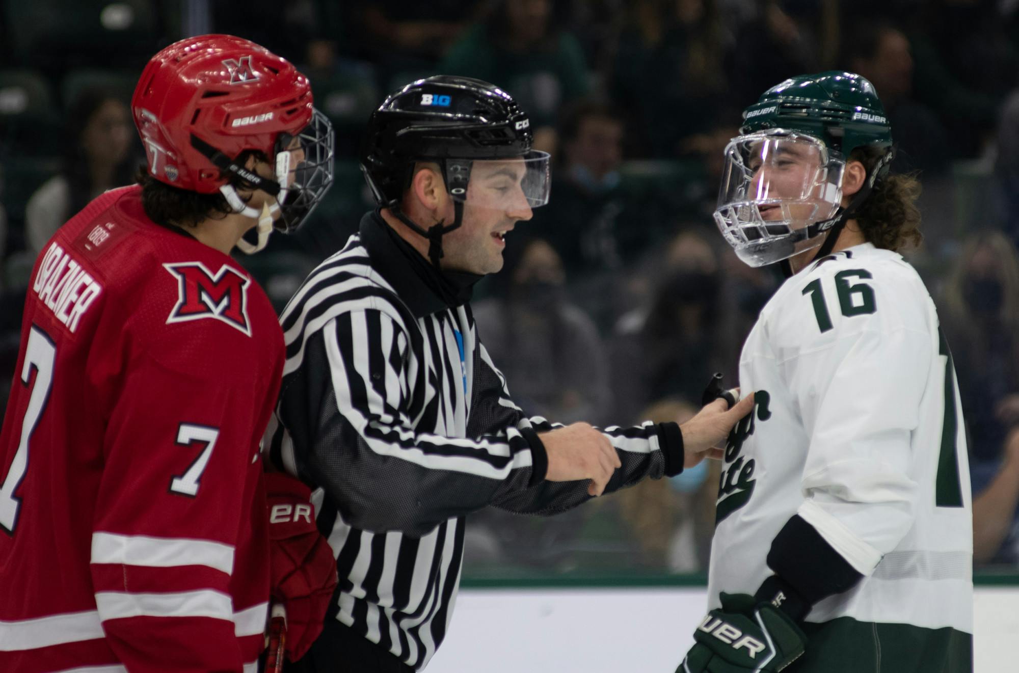 <p>Spartan freshman left wing Jesse Tucker is separated from Redhawks sophomore defenseman Robby Drazner by a referee during the teams&#x27; match on Friday, Oct. 11, 2021. </p>