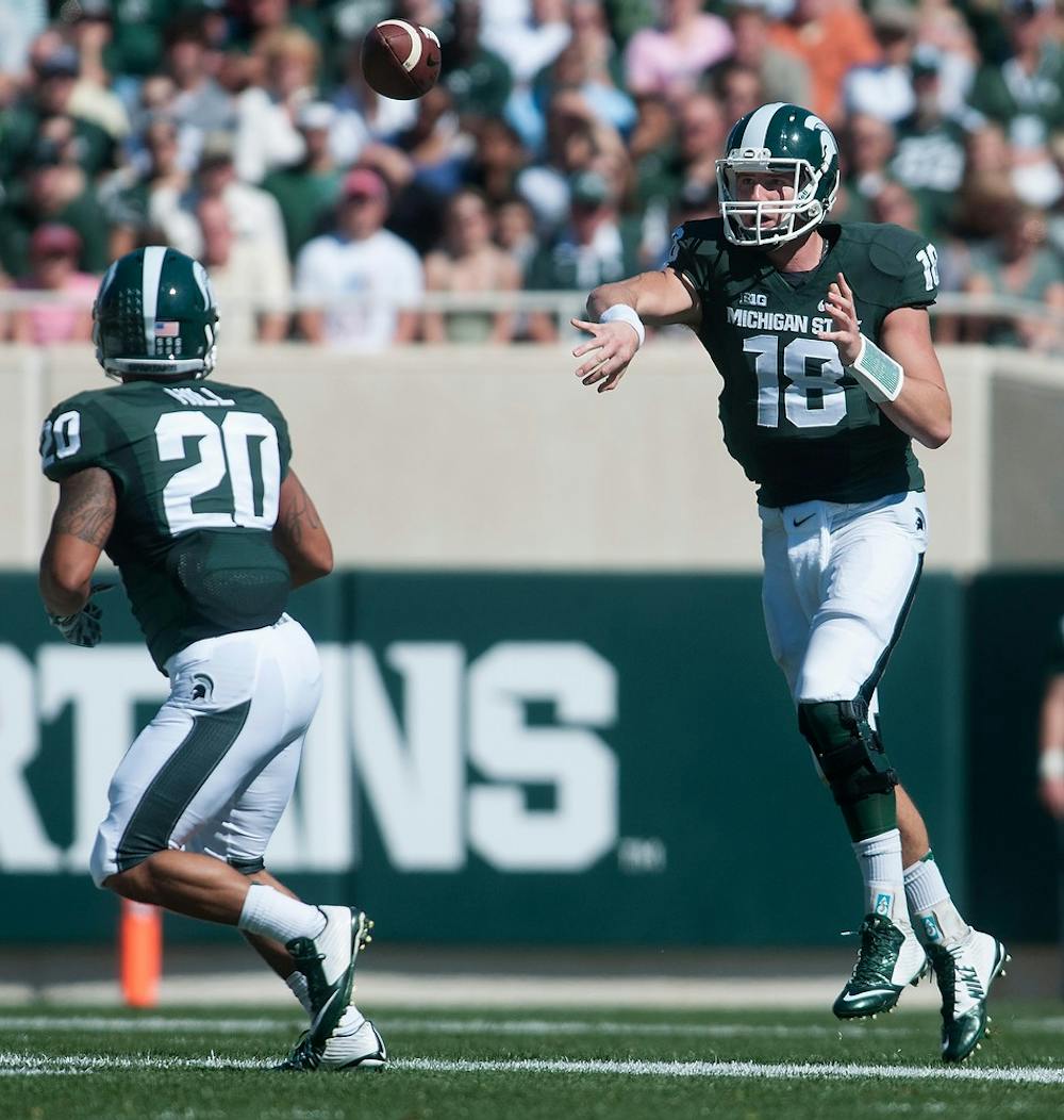 <p>Junior quarterback Connor Cook passes to senior running back Nick Hill during the game against Wyoming on Sept. 27, 2014, at Spartan Stadium. The Spartans defeated the Cowboys, 56-14. Julia Nagy/The State News</p>