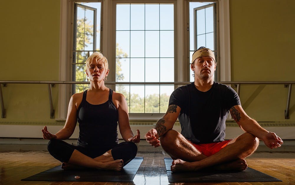 <p>Logan Stark, senior in professional writing and yoga instructor Kintla Ernst, enjoy a yoga session Sept. 26, 2014, at IM Circle. Stark and Ernst participated in a study by Jason Moser, an assistant professor of psychology, on the effects on yoga on the brain. Photo Courtesy of G.L Kohuth</p>