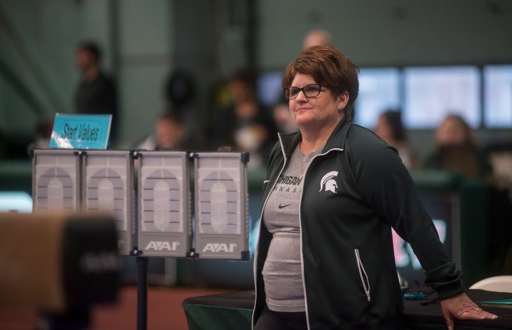 Head coach Kathie Klages watches the team warm up for beam on Feb. 13, 2015, at the women's gymnastics meet against Michigan. Michigan defeated Michigan State with a score of 196.725-194.850. Emily Nagle/The State News