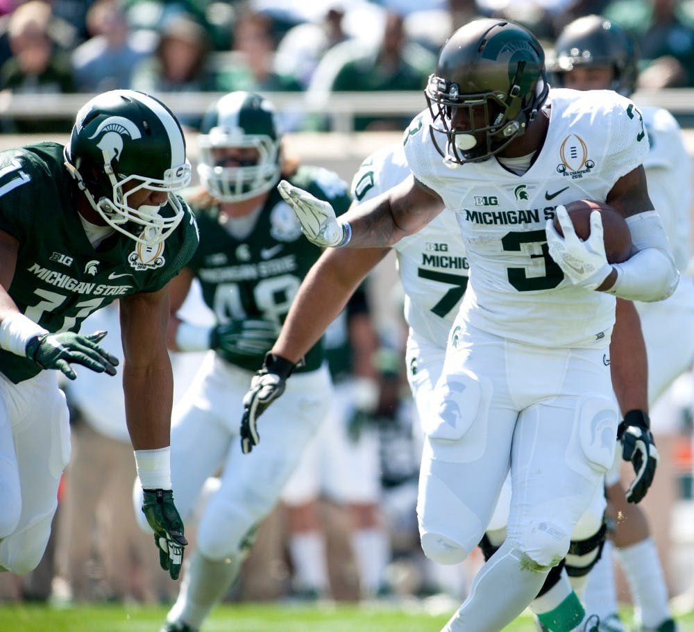 Sophomore running back LJ Scott runs that ball as he is defended by senior tight end Jamal Lyles during the Green and White scrimmage on April 23, 2015 at Spartan Stadium. The White team defeated the Green team, 14-11. 