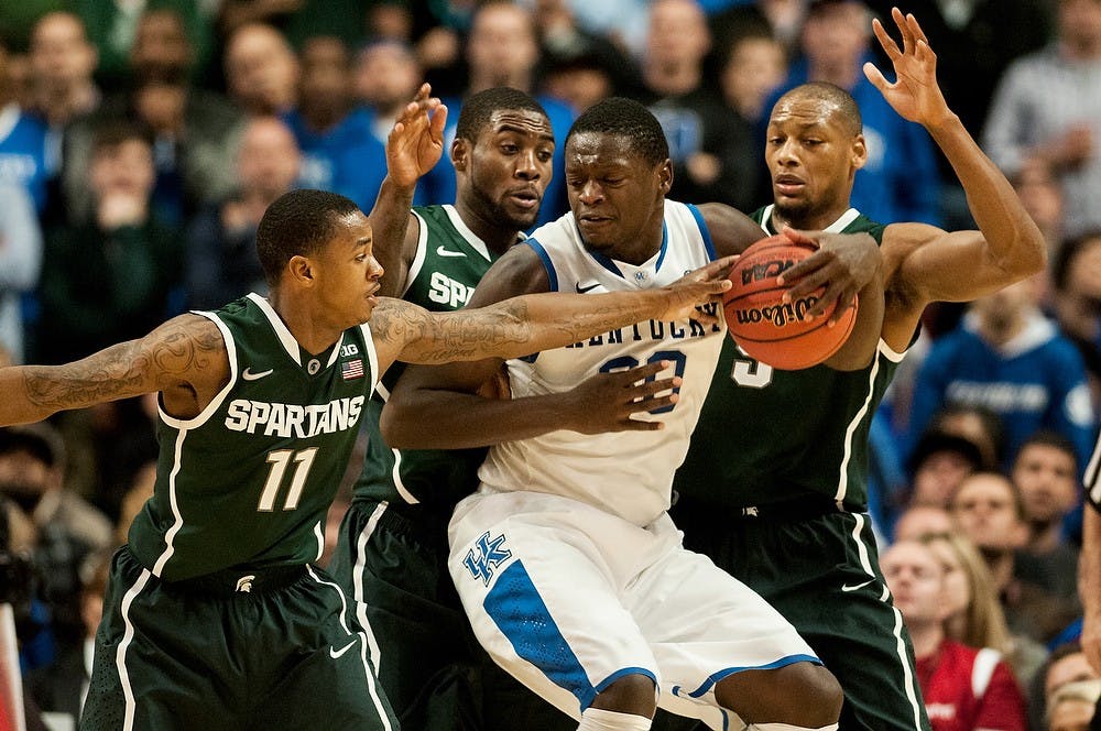 <p>Then senior guard Keith Appling, 11, then junior guard Branden Dawson, 22, and then senior center Adreian Payne, 5 guard around Kentucky forward Julius Randle during the game against Kentucky on Nov. 12, 2013, at the Champions Classic at The United Center in Chicago, IL. The Spartans defeated the Wildcats, 78-74. Khoa Nguyen/The State News</p>