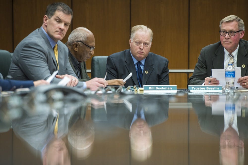 <p>Bill Beekman, center, looks on as he is accepted the role of MSU's acting president during the MSU Board of Trustees public meeting discussing MSU's presidential transition on Jan. 26, 2018 at the Hannah Administration Building. (Nic Antaya | The State News)</p>