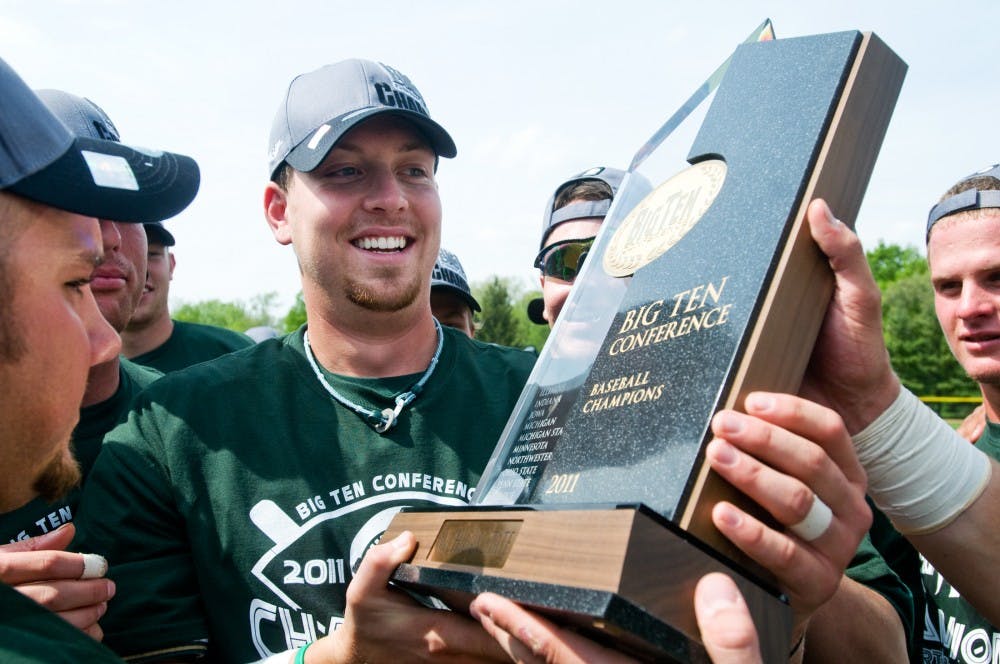 	<p>Senior first baseman Jeff Holm holds the Big Ten Championship trophy as his teammates gather around to get a look Saturday at McLane Stadium. The Spartans have earned a share of the Big Ten Championship for the first time since 1979.</p>