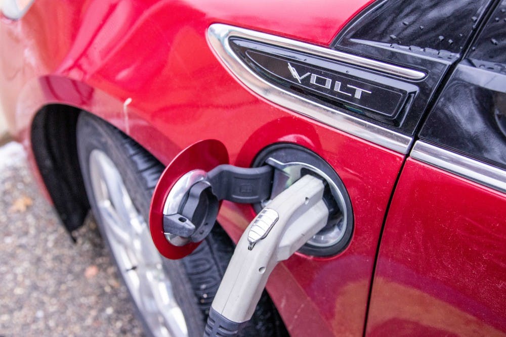 <p>A car charges at the station outside the East Lansing Public Library Dec. 5.</p>